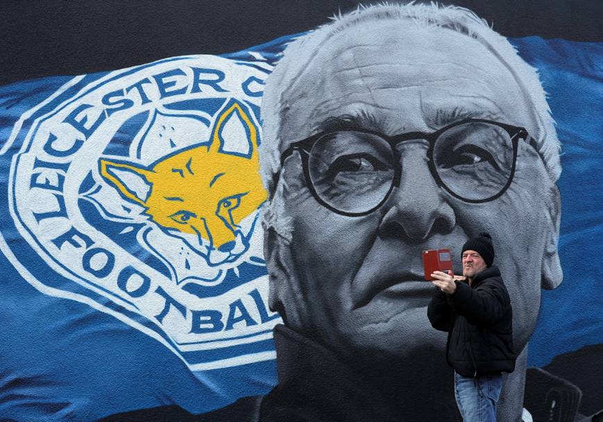 Un uomo fa un selfie con alle spalle la gigantografia di Claudio Ranieri esonerato dal Leicester dopo la sconfitta della squadra in Champions League (Lapresse)